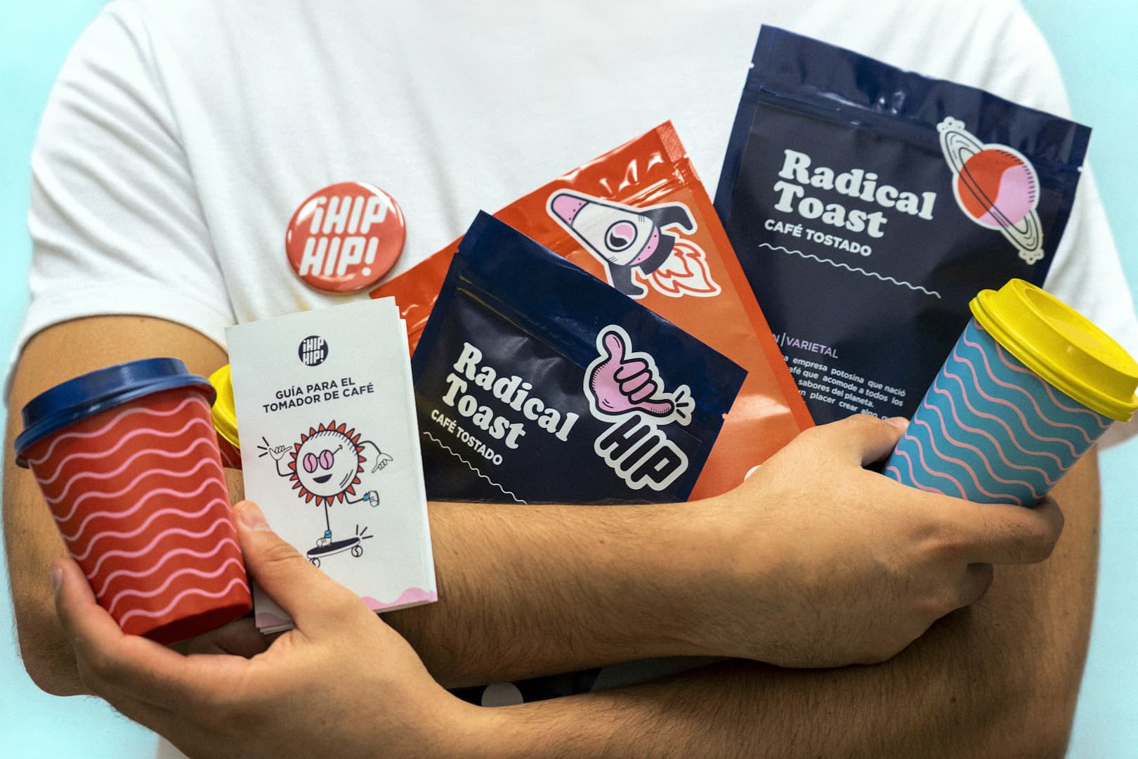 Verpackungen, Becher und Sticker der Kaffeemarke ¡HIP HIP! im Arm getragen